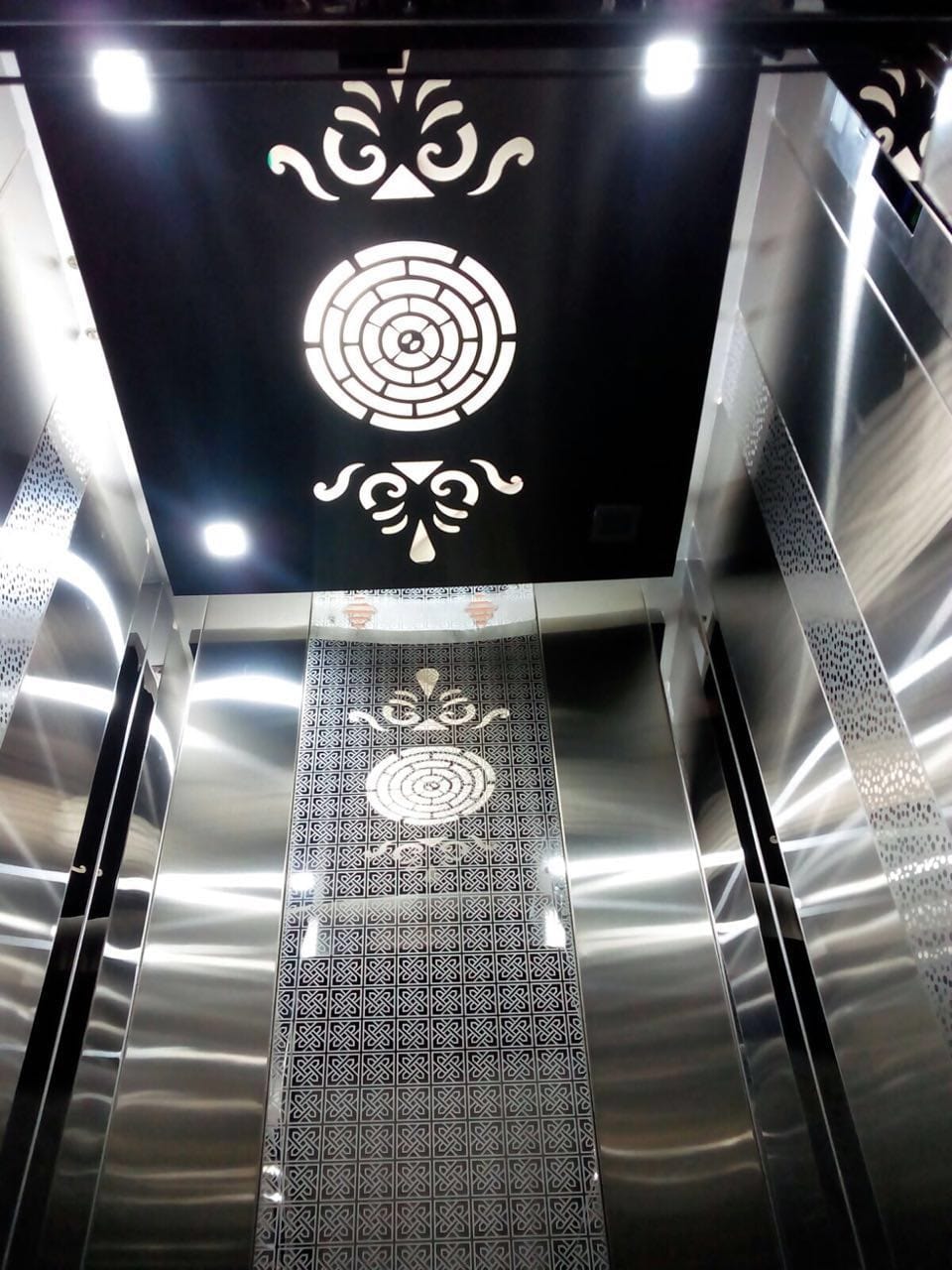 Modern elevator interior with ornate ceiling design